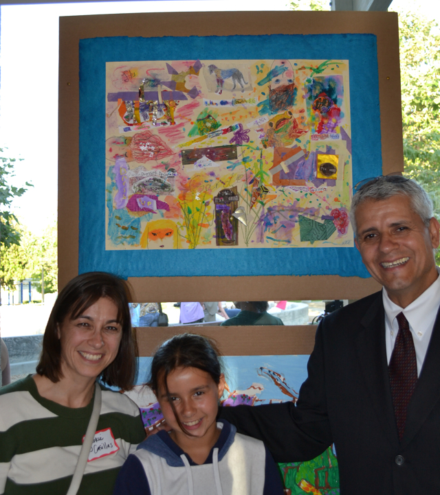 Arnoldo (right) and Jackie Casillas (left) stand by their daughter, 5th grader Isabella (center), under her collage work.