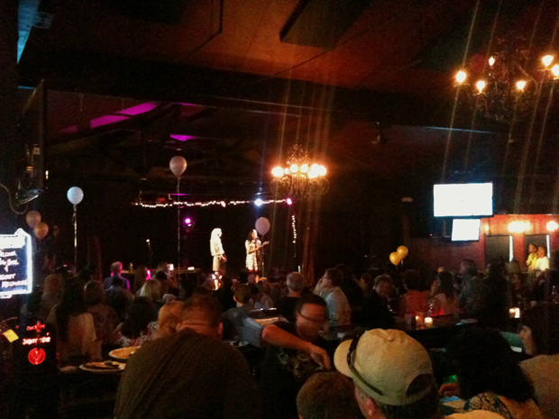 Vice-Mayor Suja Lowenthal address a packed Gaslamp as  secret millionare  Hilary Decesare looks on