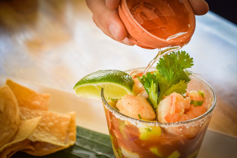A shot of mezcal poured over Lola's shrimp cocktail. Photo by Brian Addison.