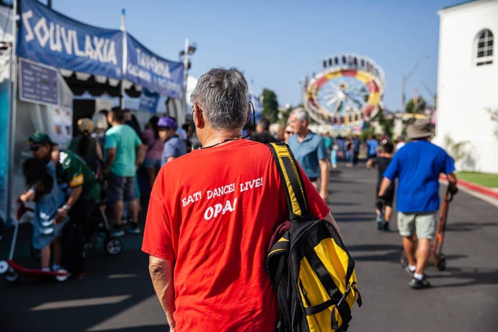 Tony Chew lives it up walking through the Greek Fest with his "Eat! Dance! Live! OPA!" shirt in Long Beach Sunday, September 2, 2018. Photo by Kelly Smiley