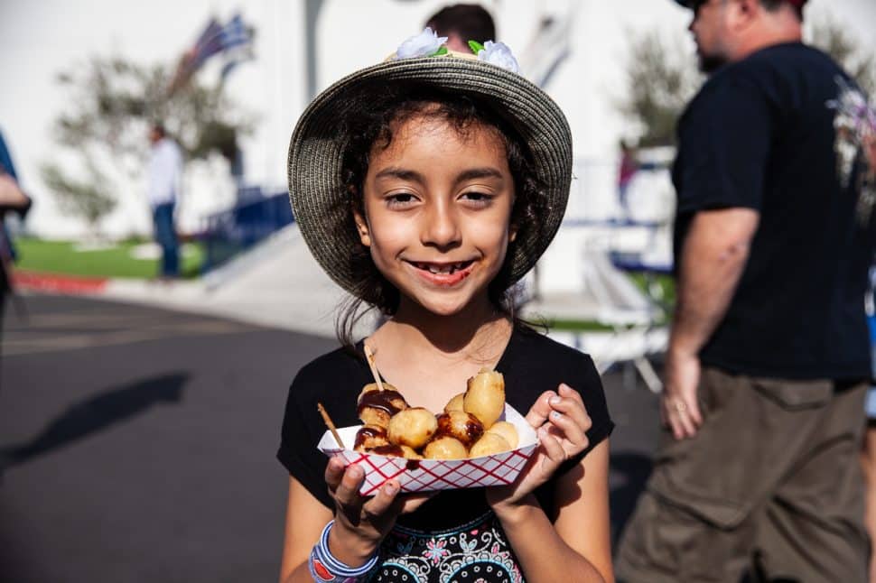 Elena Gonzalez smiles with her chocolate covered Greek Donuts from the Loukoumades' booth at the Greek Fest in Long Beach Sunday September 2, 2018. Photo by Kelly Smiley