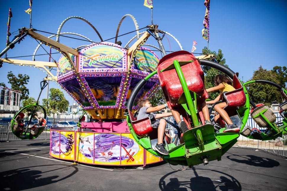 Thrill seekers at the Greek Fest hang on as they spin around the Tornado ride in Long Beach Sunday September 2, 2018. Photo by Kelly Smiley