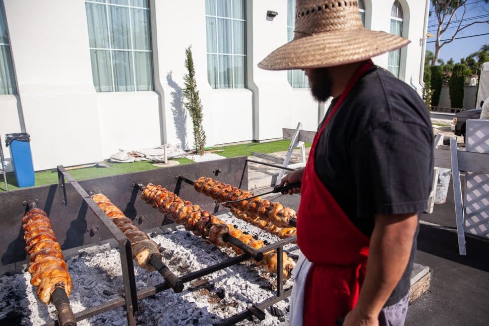George Rivera bastes chickens with a mixture of lemon juice, olive oil and oregano to keep them hydrated and fresh at the Greek Fest in Long Beach Sunday, September 2, 2018. Photo by Kelly Smiley