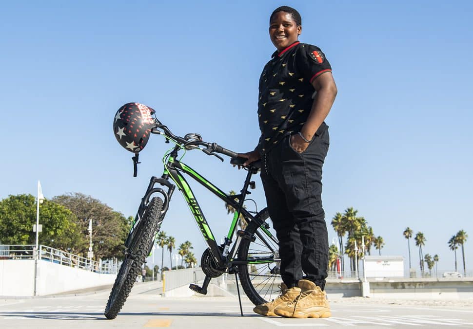 Jassiah Smith,14 of Long Beach, stands next to his new bike after the Long Beach police took a collecting to replace his bike after it was stolen over the weekend in Long Beach October 23, 2018. Photo by Thomas R Cordova.