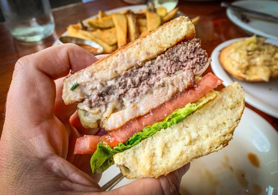 Even upside down, 4th & Olive's classic burger complete with a slice of house-cured pork is solid. Photo by Brian Addison.