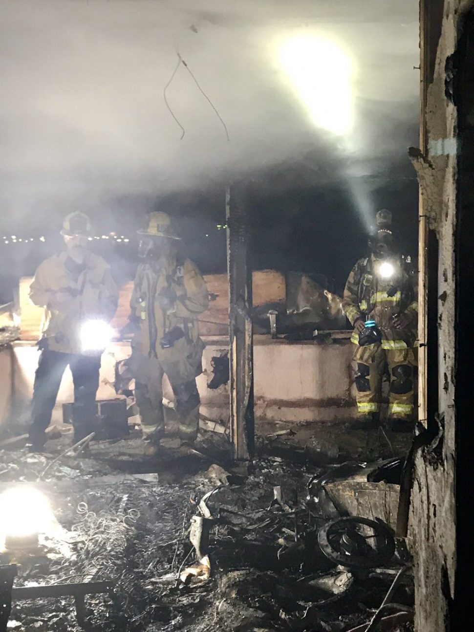 Firefighter survey the damage from the fatal fire. Photo courtesy the Long Beach Fire Department.
