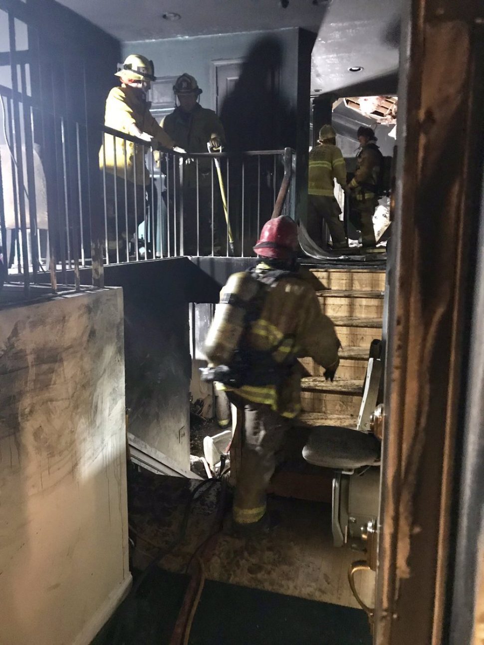 Firefighter survey the damage from the fatal fire. Photo courtesy the Long Beach Fire Department.