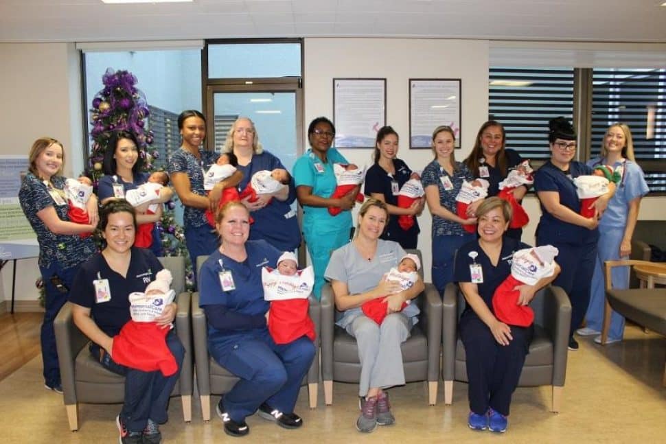 Newborns adorn giant, red Christmas stockings, held by Miller Children’s & Women’s nurses, in celebration of the upcoming holiday.